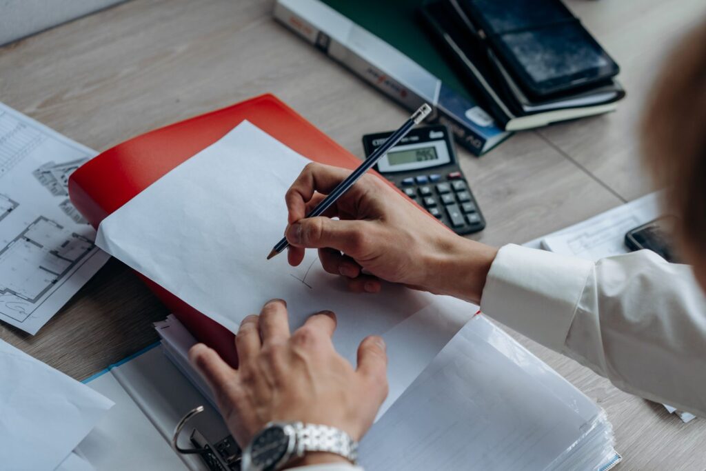 Owner reviewing a renovation quote with a calculator and floor plans